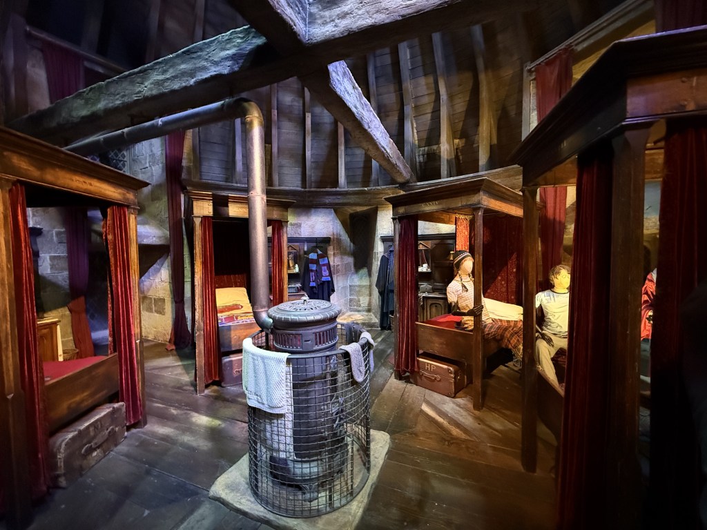 Unutrašnjost Gryffindor spavaonice sa četirima krevetima i kaminom, u Warner Bros. Studio Tour London.